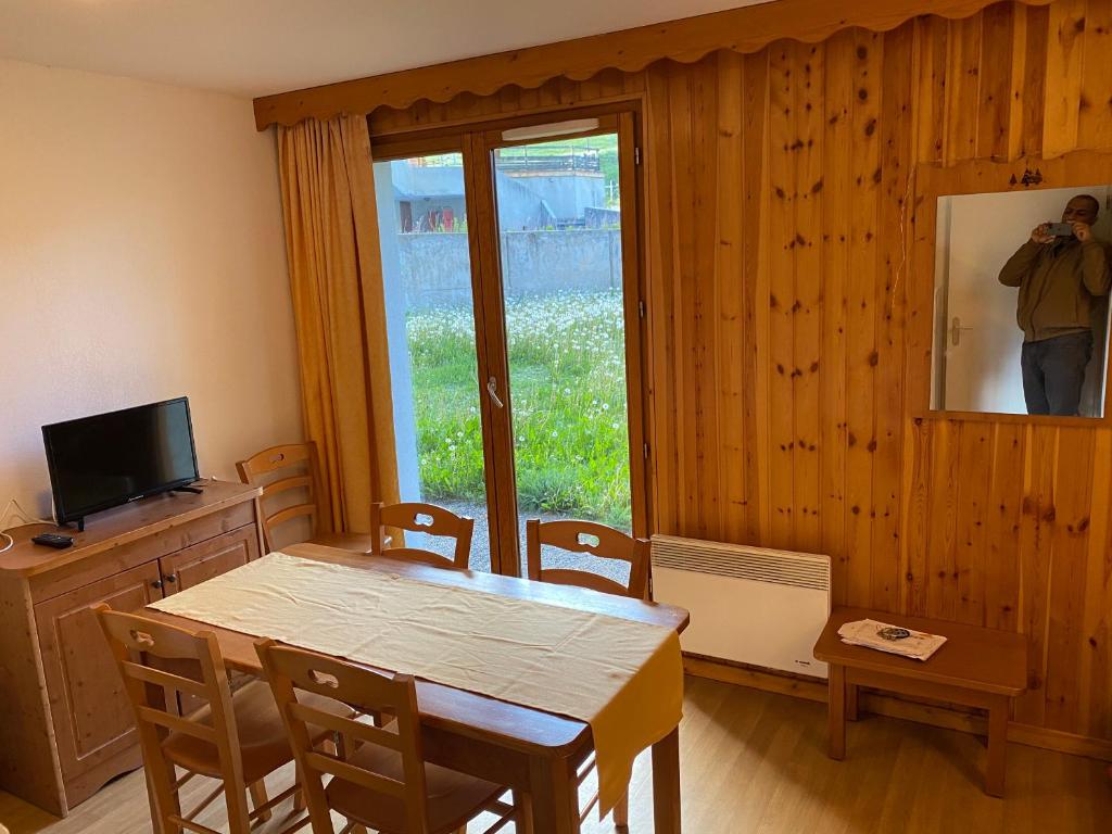 a dining room with a table and chairs and a window at residence clos la Chalp II in Molines-en-Queyras