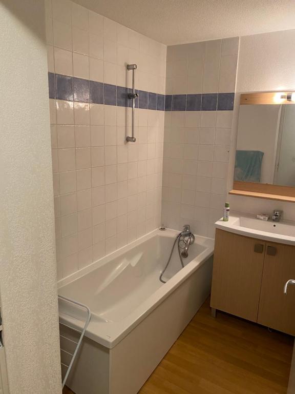 a bathroom with a bath tub and a sink at residence clos la Chalp II in Molines-en-Queyras
