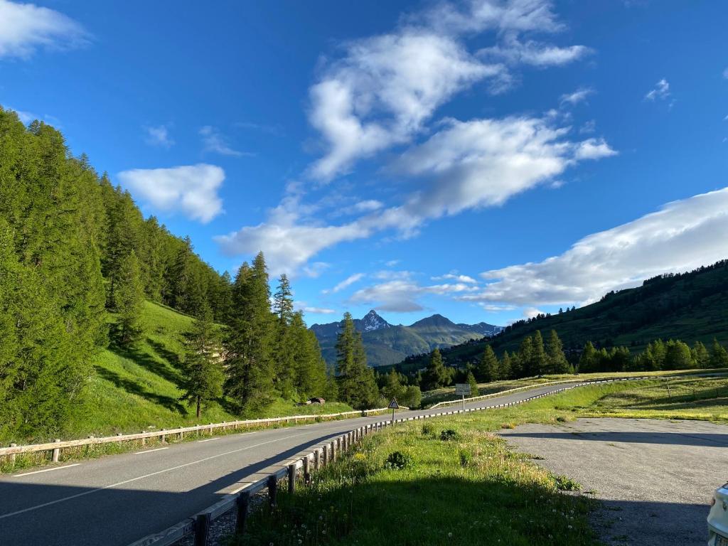 an empty road in the mountains under a blue sky at residence clos la Chalp II in Molines-en-Queyras