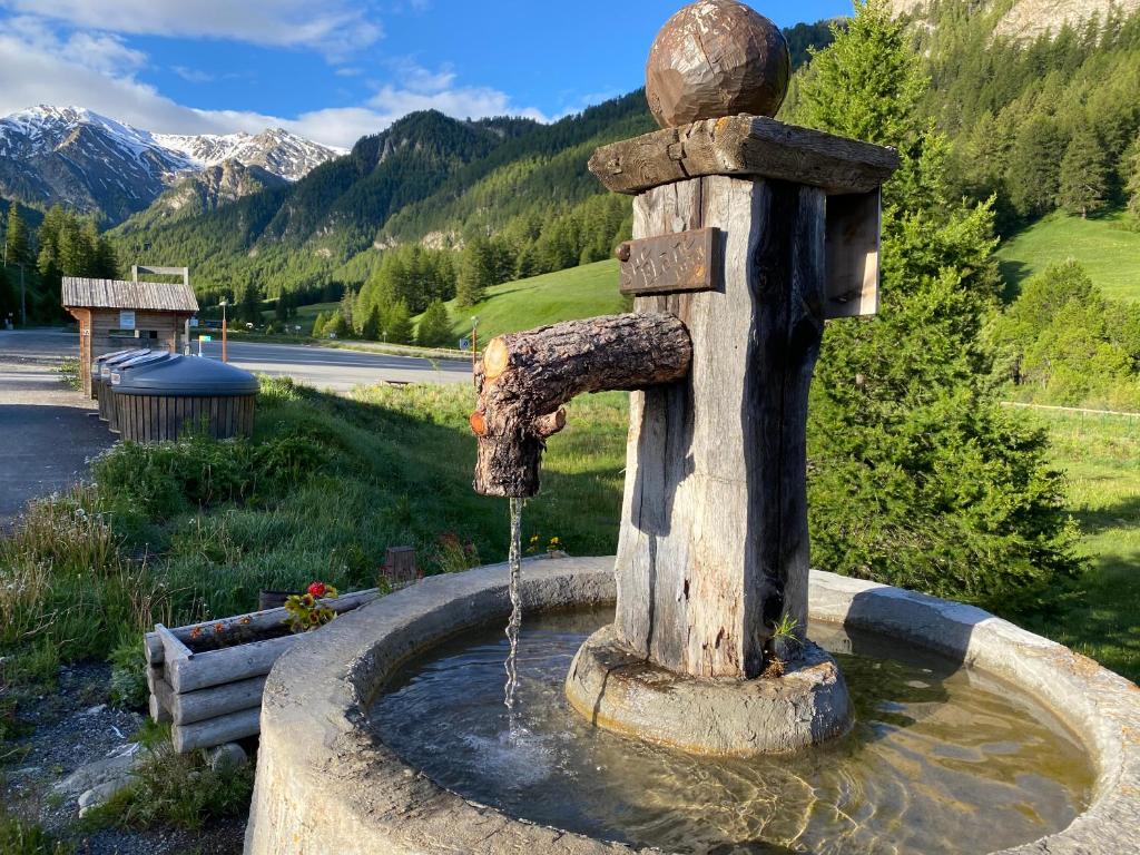 a stone water fountain in the middle of a road at residence clos la Chalp II in Molines-en-Queyras