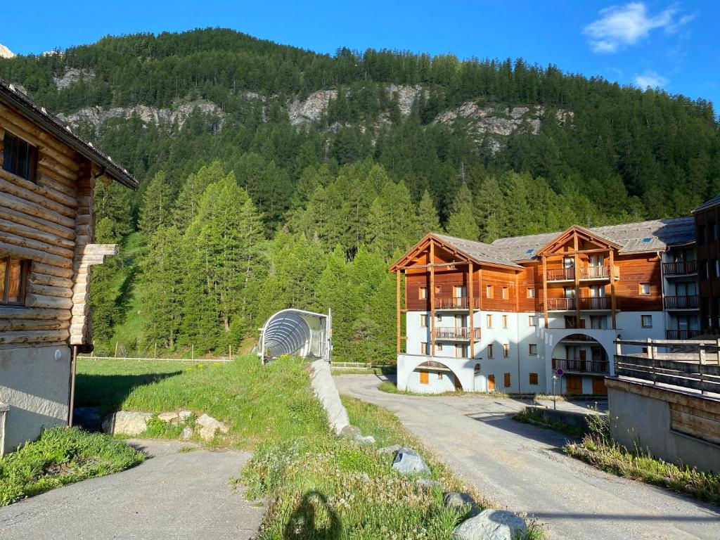 a large building with a fan in front of a mountain at residence clos la Chalp II in Molines-en-Queyras