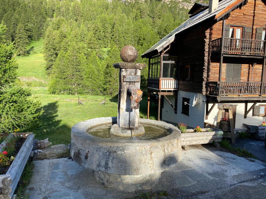 a stone fountain in front of a house at residence clos la Chalp II in Molines-en-Queyras