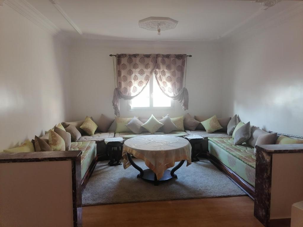a living room with a couch and a table at Huge Cozy Apartment in Larache