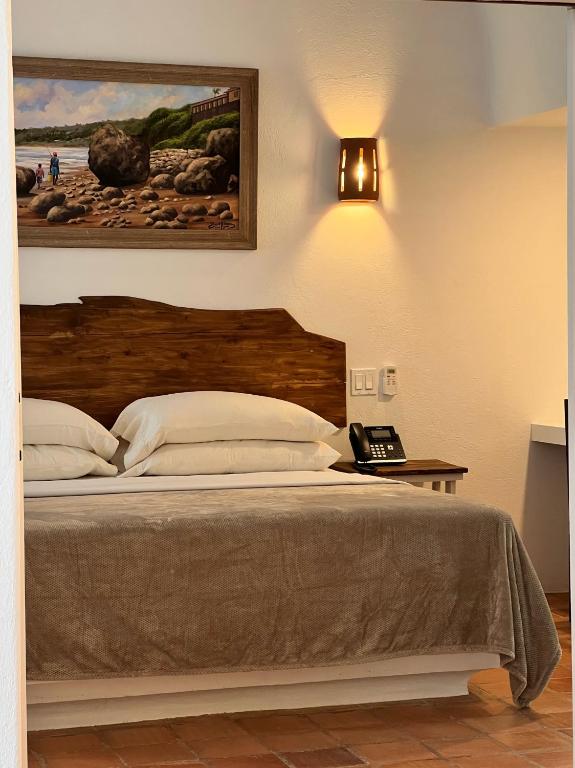 a bed with a wooden headboard in a bedroom at OceanBlue Resort in Christ Church