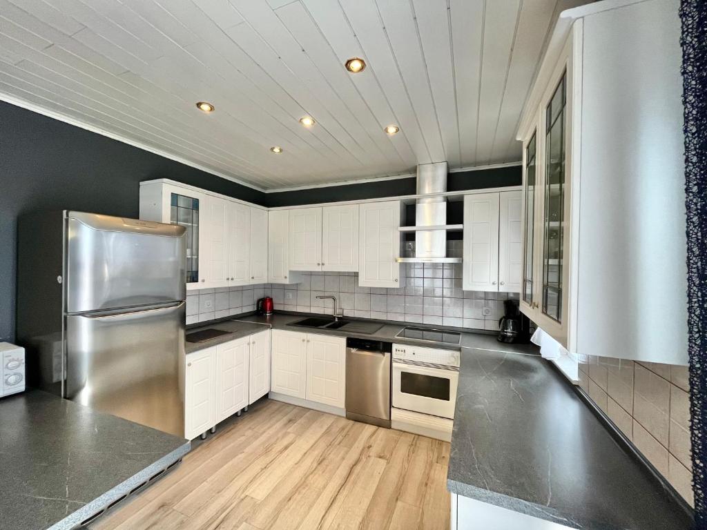 una cucina con armadi bianchi e frigorifero in acciaio inossidabile di Apartments Rino a Vodice