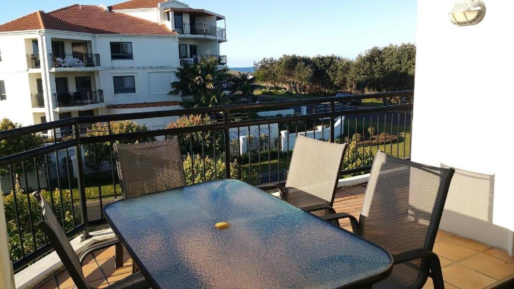a table and chairs on a balcony with a ball on it at The Sands Unit 9 in Yamba