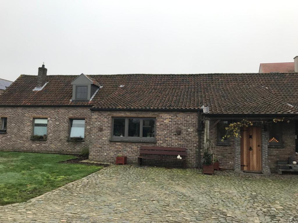 a brick house with a bench in front of it at CasaDeKaMa in Evergem