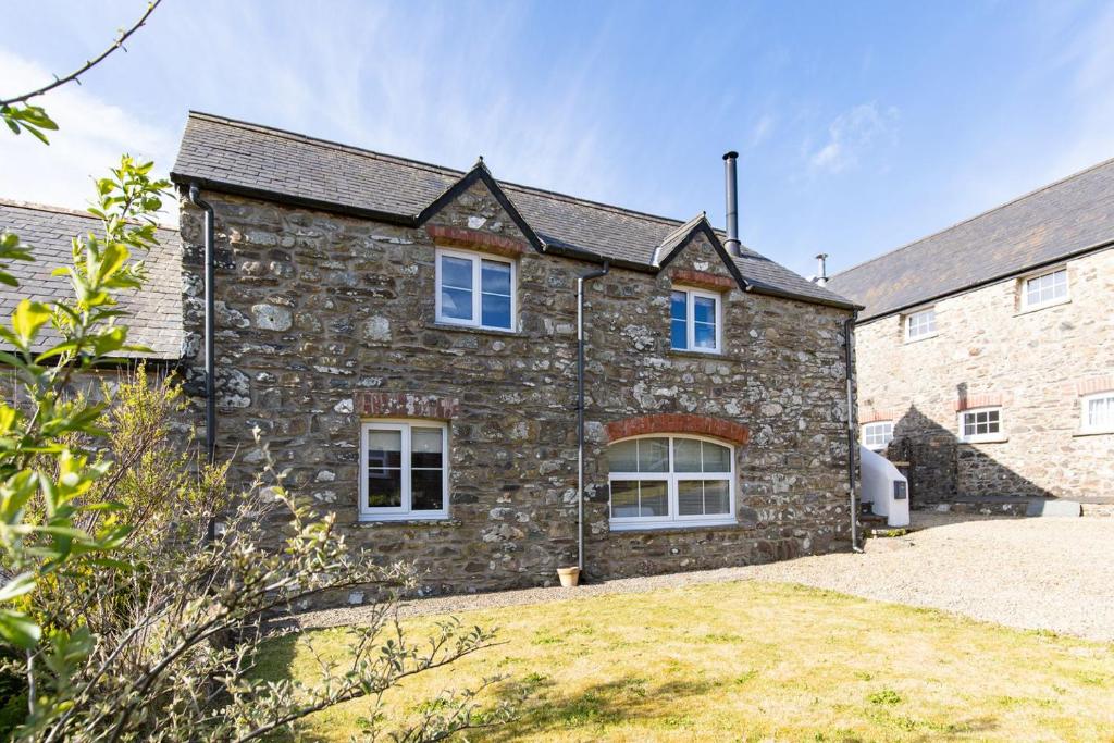 an old stone house with a yard in front of it at Summerhill Cottage in Mathry