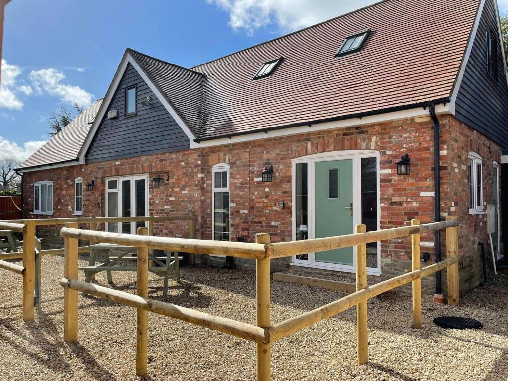 a brick house with a green door and a fence at The Willows - Uk34000 in Child Okeford