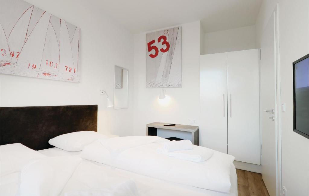 トラフェミュンデにある2 Bedroom Beautiful Apartment In Lbeck Travemndeのベッドルーム(白いベッド2台、テレビ付)