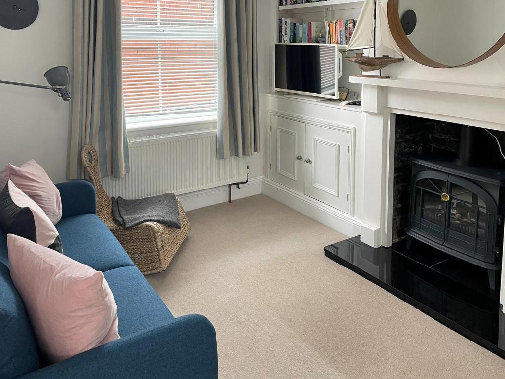 a living room with a blue couch and a fireplace at Evelyn Cottage in Dartmouth