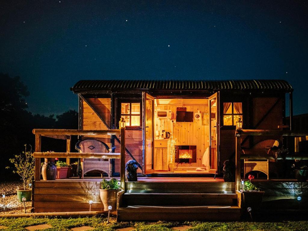 a tiny house with a porch at night at Nirvana in Stoodleigh