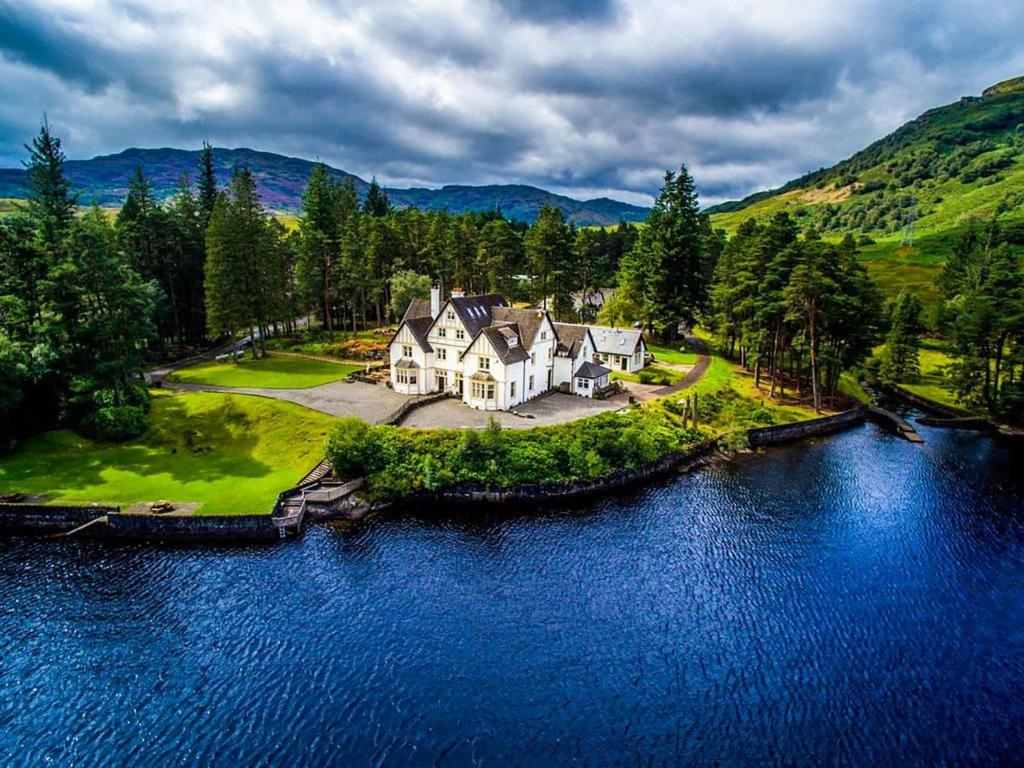 an aerial view of a house on an island in the water at Lochside House in Stronachlachar