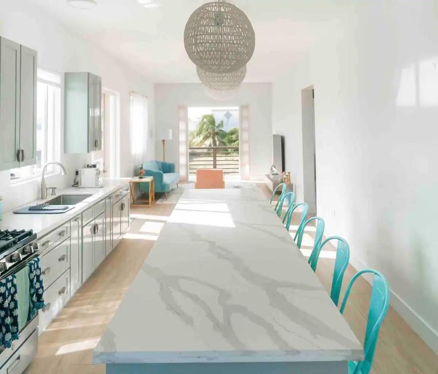 a large white kitchen with a long table and chairs at Coconut Breeze 2 in Saint Philip