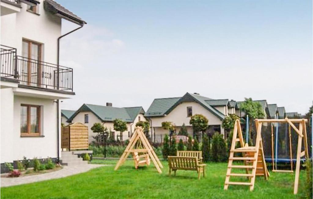 a playground in a yard next to a house at Amazing Apartment In Karwia With Heated Swimming Pool in Karwia