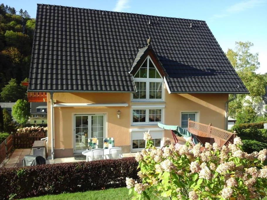 een huis met een zwart dak erop bij Ferienhaus Perle am Fuße der Augustusburg in Augustusburg
