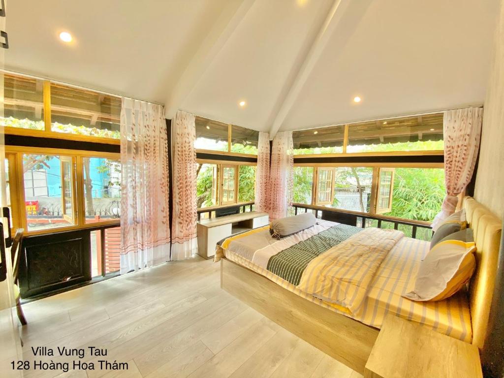 1 dormitorio con 1 cama y ventanas grandes en Chung cư 47 BACU - Bãi trước Vũng Tàu en Vung Tau