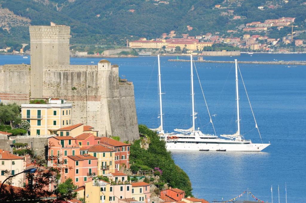 un bateau dans l'eau en face d'un château dans l'établissement Hotel Italia, à Lerici