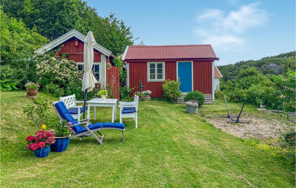 a red cottage with a red house and chairs in the yard at 4 Bedroom Cozy Home In Ells in Ellös