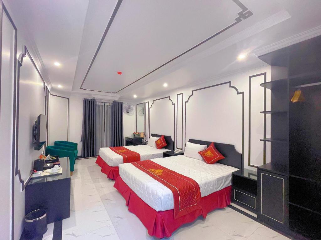 um quarto de hotel com duas camas e uma televisão de ecrã plano em Rosy Hotel em Hanói