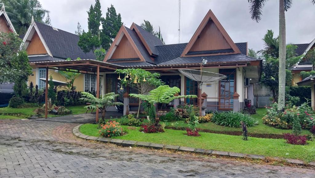 dom z ogrodem przed nim w obiekcie Pirerukafu Villa's - Villa Tipe Thailand di Kota Bunga Puncak w mieście Cimacan