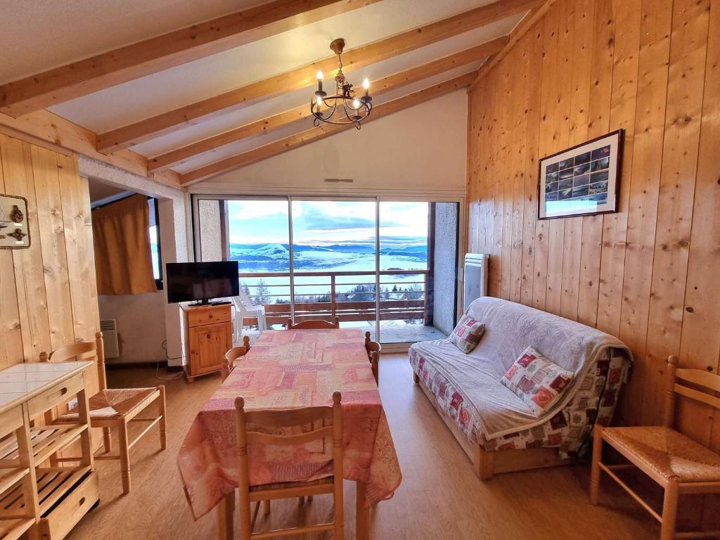 - un salon avec une table et une chambre avec vue dans l'établissement Appartement 7 pers avec balcon, wifi, animaux admis, parking - Saint-Michel-de-Chaillol - FR-1-393-88, à Saint-Michel-de-Chaillol