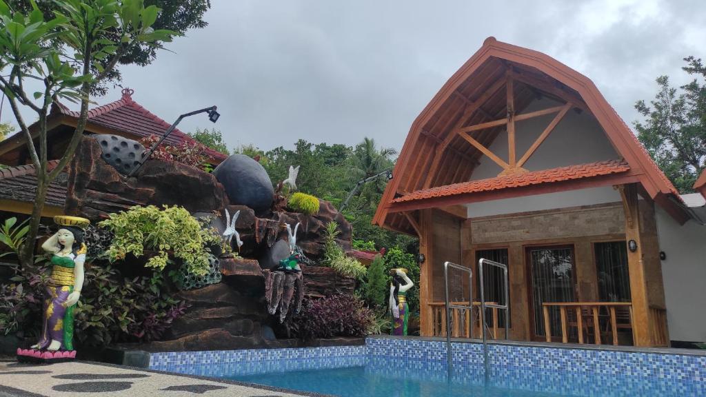 une maison avec une cascade à côté d'une piscine dans l'établissement Kristal Garden, à Sekotong