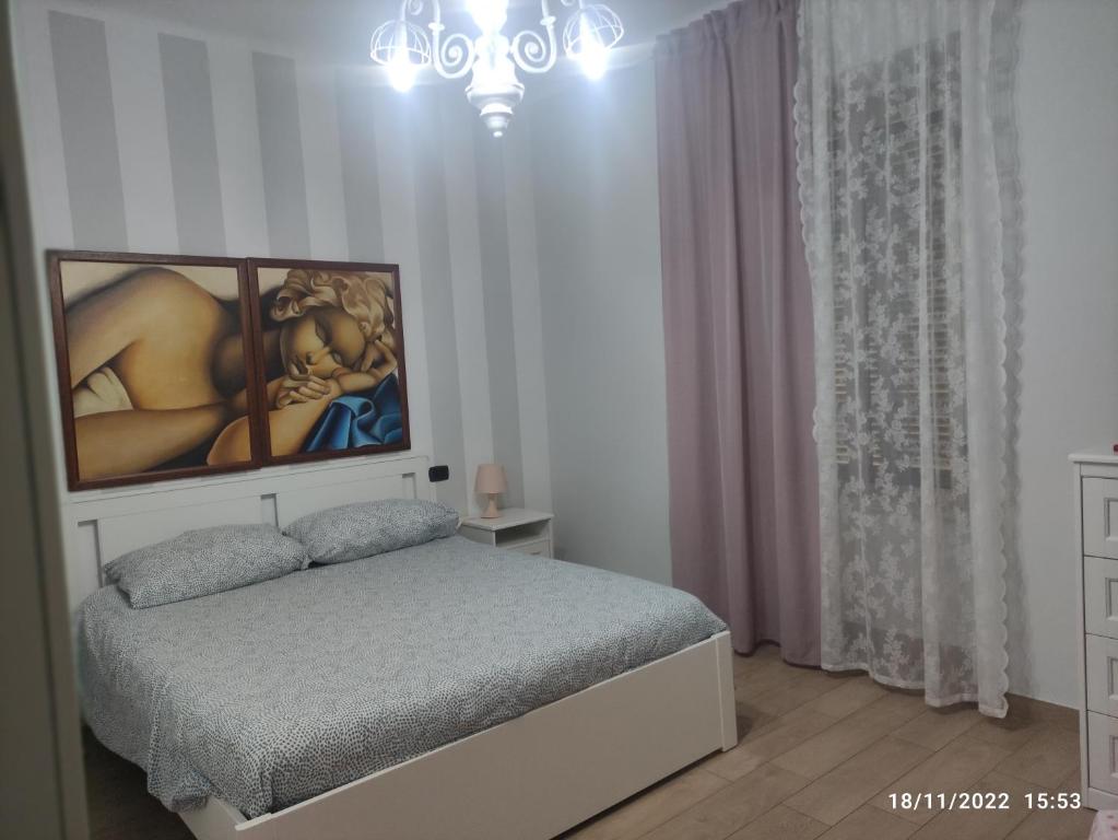sypialnia z łóżkiem i obrazem na ścianie w obiekcie Certe notti w mieście Tarent