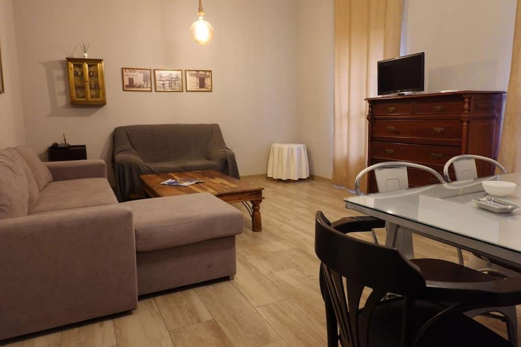 sala de estar con sofá y mesa con sillas en En el corazón de la ciudad, en Badajoz