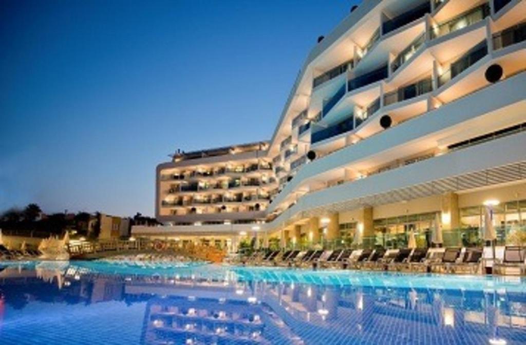 a large hotel with a large swimming pool at night at Selene Beach & Spa Hotel - Adult Only - Ultra All Inclusive in Avsallar