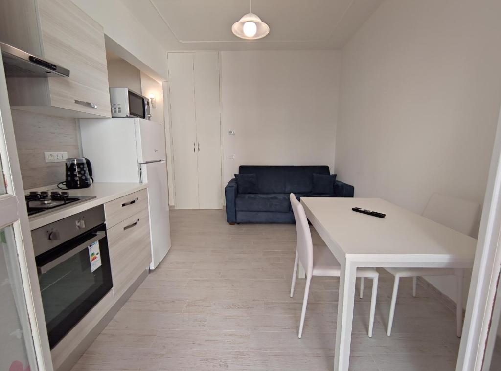 a small kitchen with a white table and a blue couch at Oasi - By Ligooria in Pietra Ligure