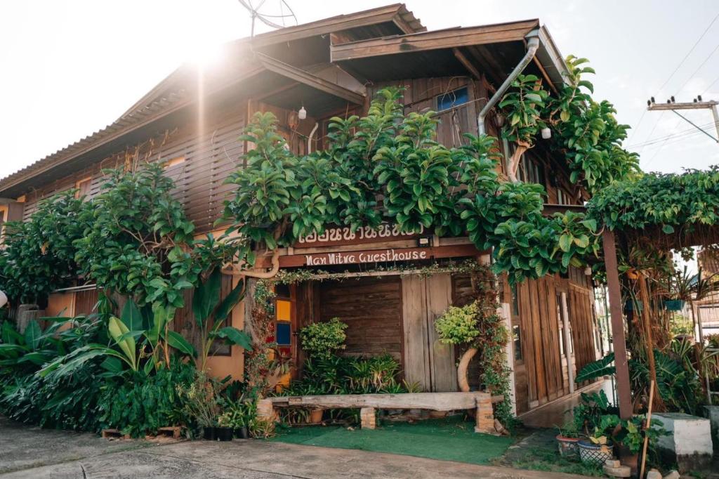 Un bâtiment avec un tas de plantes sur lui dans l'établissement เฮือนน่านนิทรา, à Nan