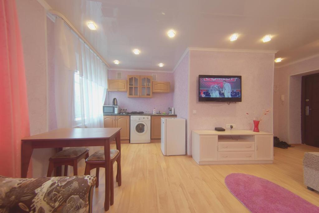 a living room with a table and a kitchen at Apartment Northern Lights in Murmansk