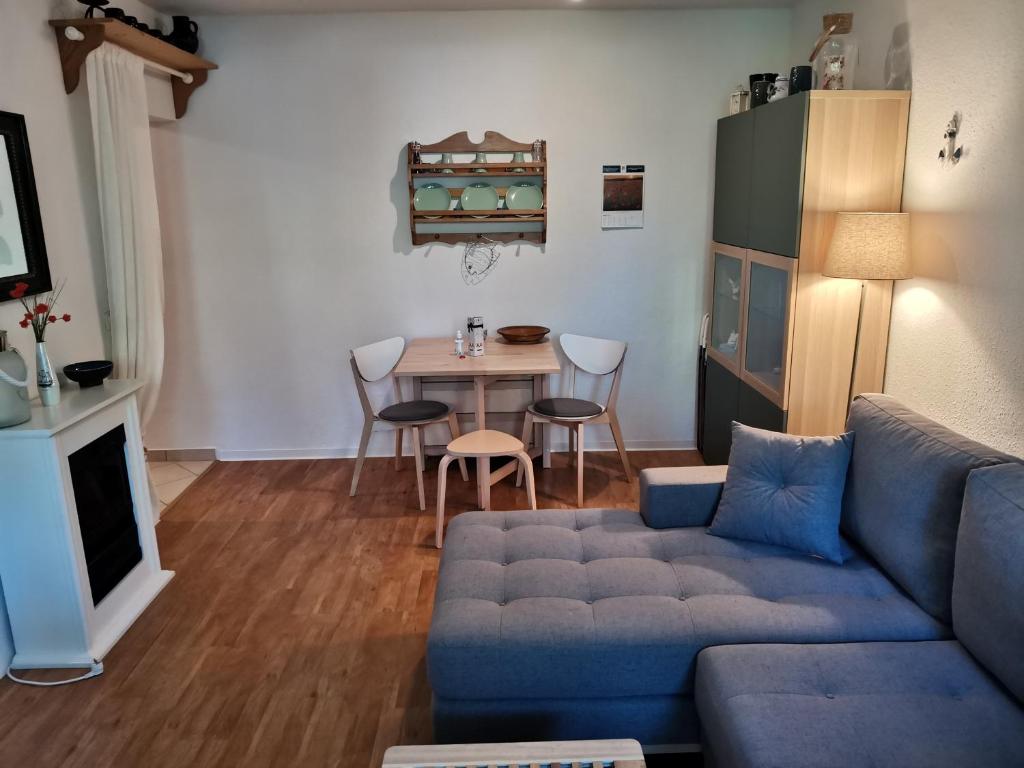 ein Wohnzimmer mit einem blauen Sofa und einem Tisch in der Unterkunft Kleine Ferienwohnung am Strand in Kühlungsborn in Kühlungsborn