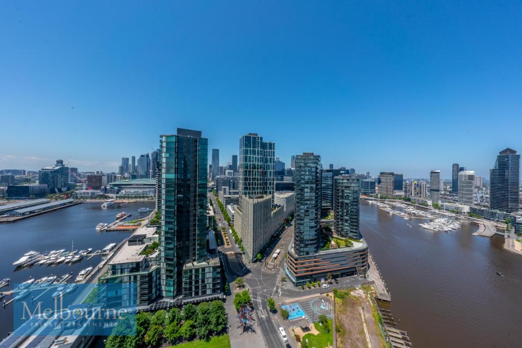 une vue aérienne sur une ville avec une rivière et des bâtiments dans l'établissement Melbourne Private Apartments - Collins Wharf Waterfront, Docklands, à Melbourne