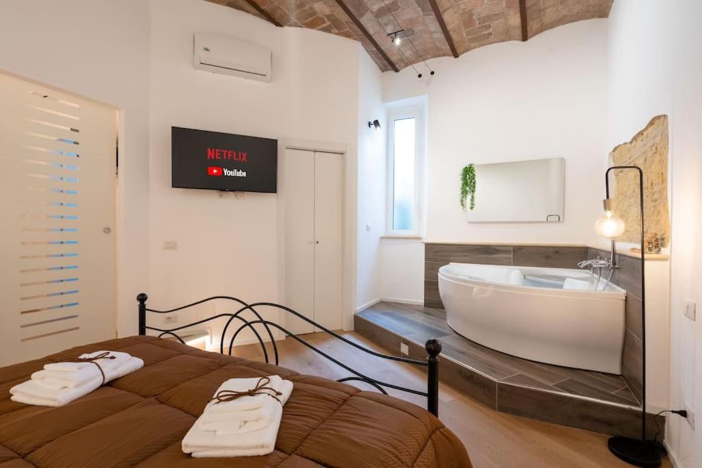 a bathroom with a bed and a tub and a sink at L'Antica Voltina in Nettuno