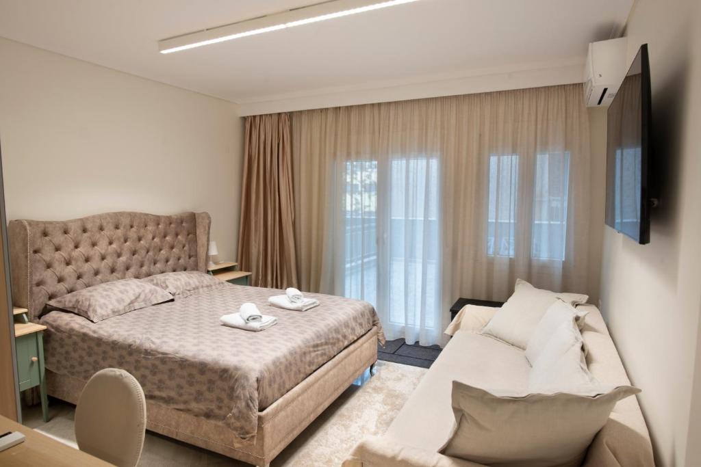 a hotel room with a bed and a couch at Ag.Sofias pedestrian area luxury ap. & big balcony in Thessaloniki