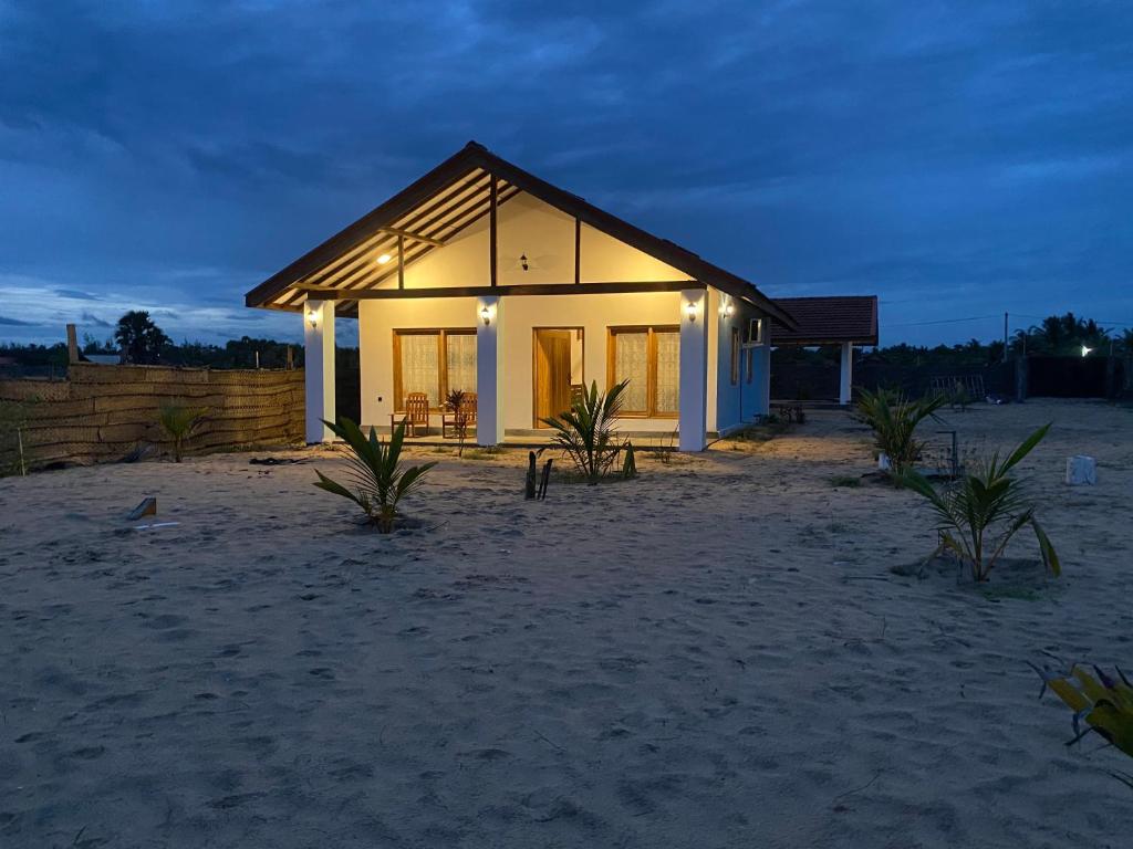 una pequeña casa en la playa por la noche en Oceano Beach Villa en Arugam Bay