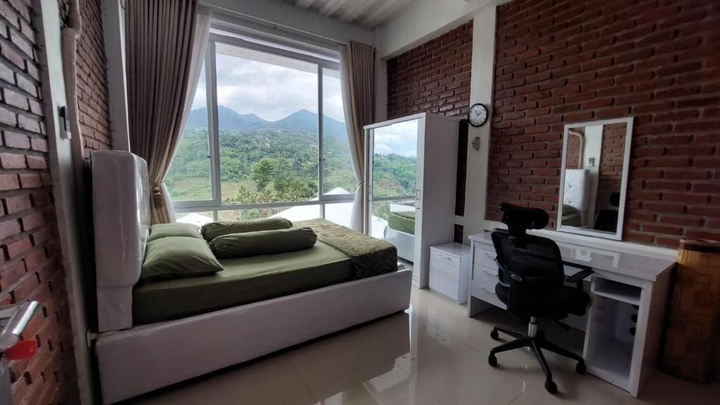 um quarto com uma cama, uma secretária e uma janela em Teras Luhur Villa & Cafe dengan Pemandangan Gunung dan Pesawahan 
