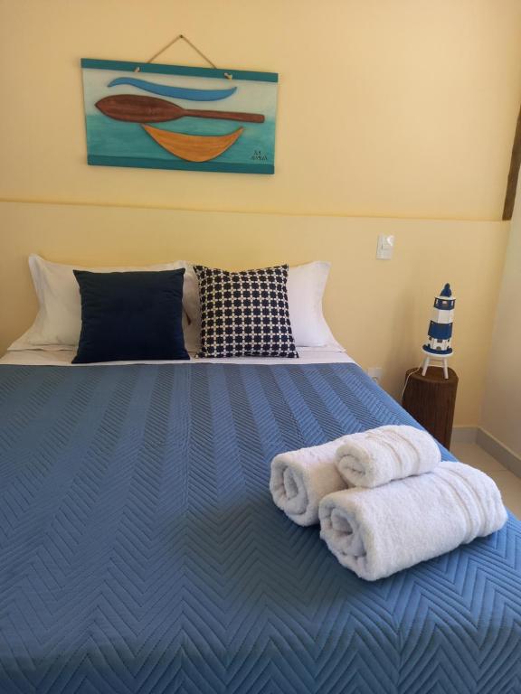 um quarto com uma cama azul com toalhas em Suítes Manjuba Praia de Sta Tereza, 800m da Vila em Ilhabela