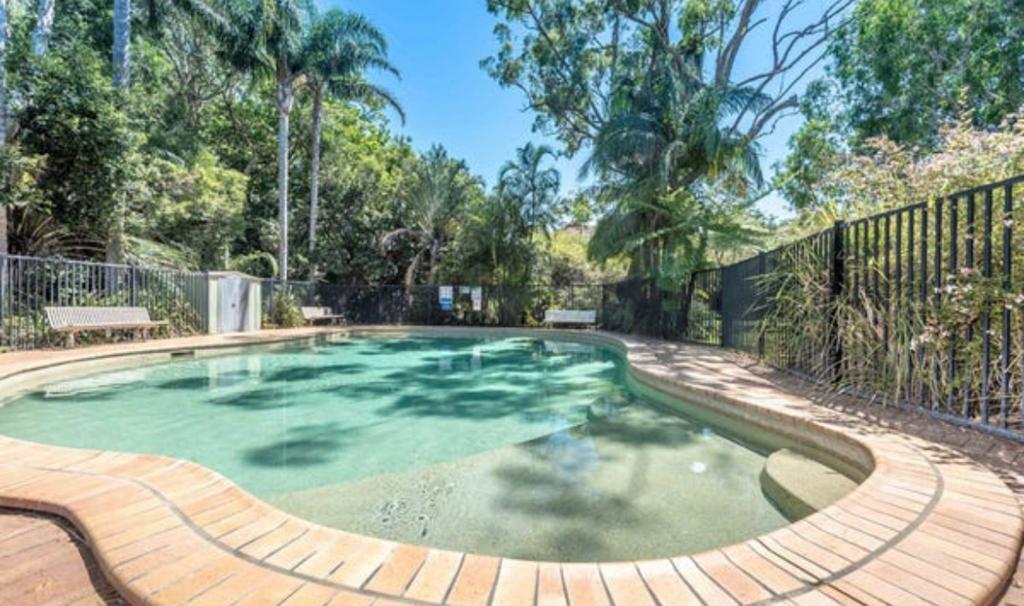 a swimming pool in a yard with a wooden fence at Coconuts - 3 bedroom 3 bathroom townhouse with tennis court in Nelson Bay