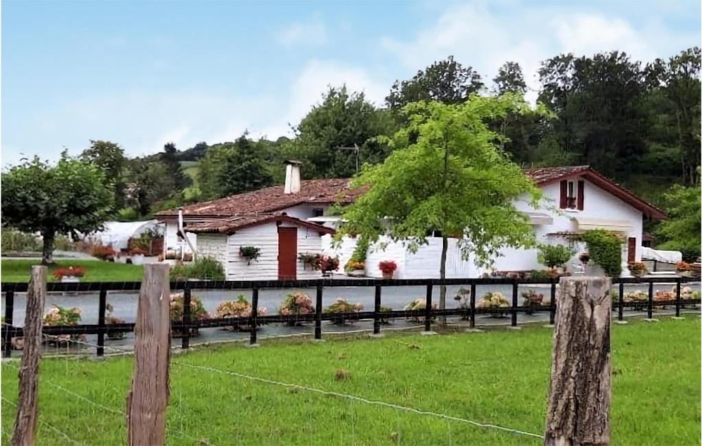 a house with a fence in front of a yard at Stunning Apartment In Saint-pe-sur-nivelle With House A Panoramic View in Saint-Pée-sur-Nivelle