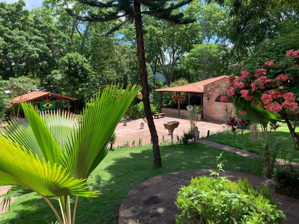 a garden with trees and flowers and a building at Pousada e Camping Lumiar in Lençóis