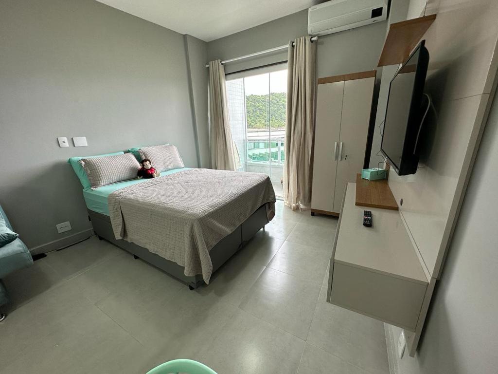 Un dormitorio con una cama y un televisor. en Flat angra, en Angra dos Reis
