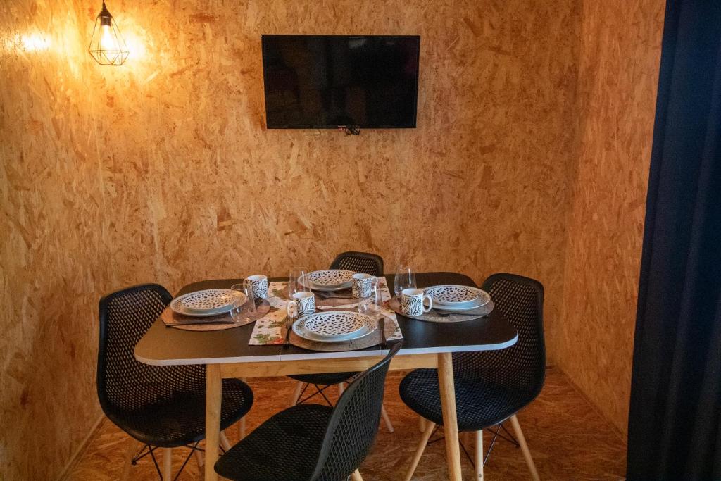 stół z krzesłami i talerzami oraz telewizor w obiekcie casinha do corvo w Fatimie