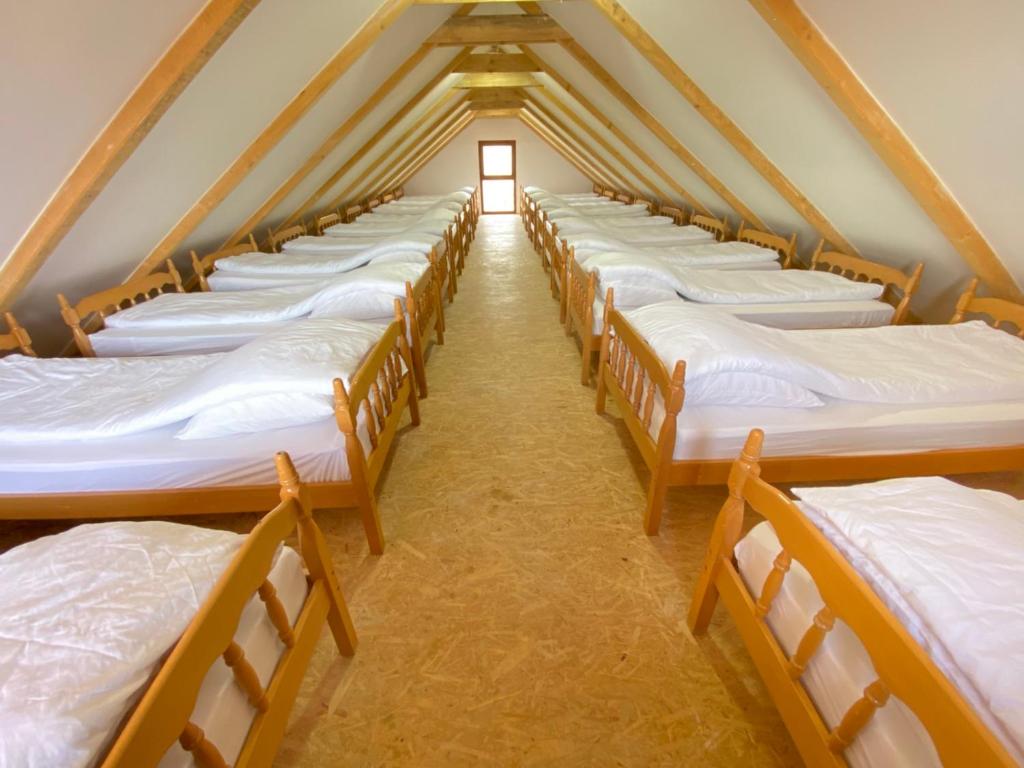 eine Reihe von Betten in einem Zimmer mit Fenster in der Unterkunft Vikend na Ozrenu in Bosansko Petrovo Selo