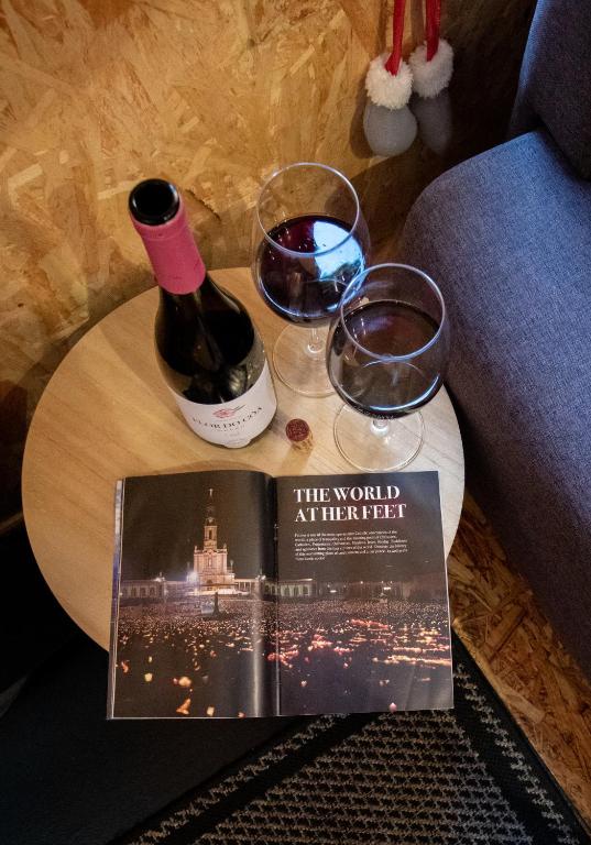 a bottle of wine and a book on a table with glasses at casinha do corvo in Fátima