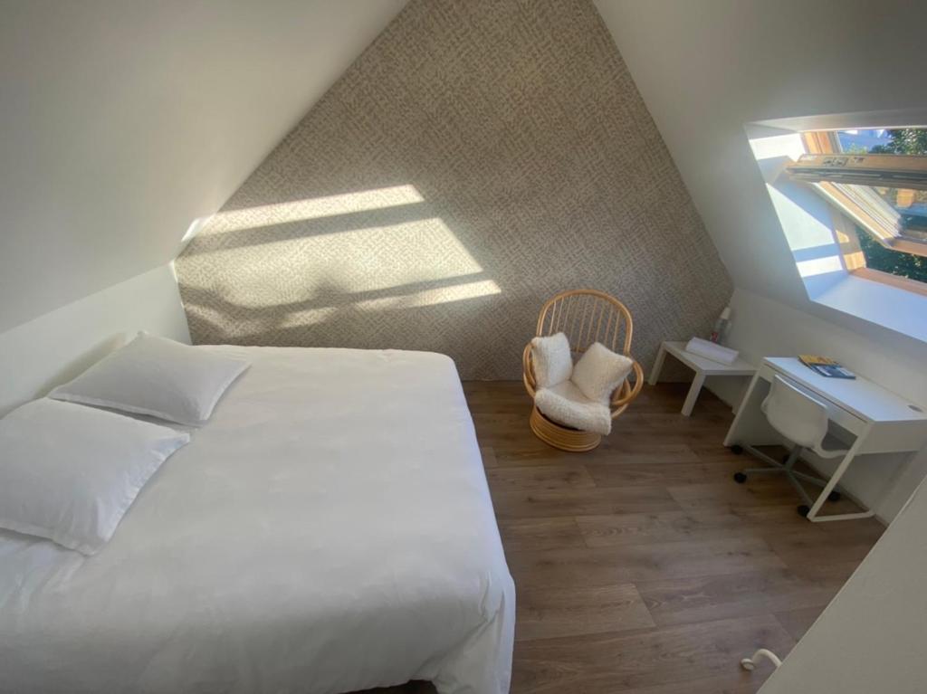 1 dormitorio con 1 cama, 1 silla y 1 ventana en Chambre chez Marjorie, en Brest