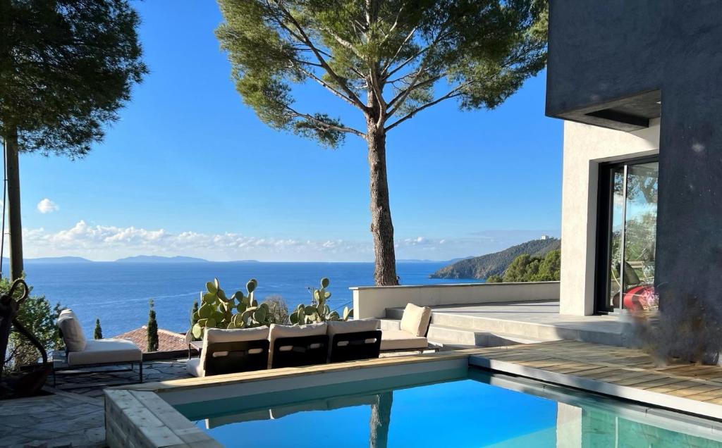 een huis met een zwembad met uitzicht op de oceaan bij Magnifique Villa Neuve Vue Mer in Cavalaire-sur-Mer