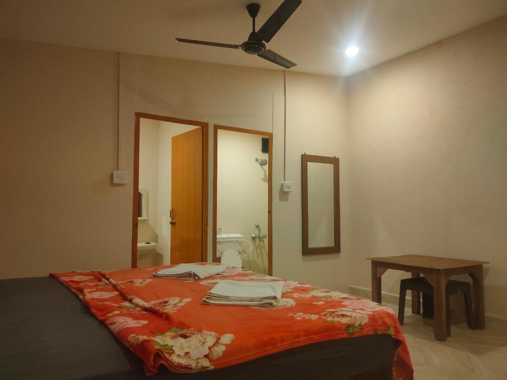 a bedroom with a bed and a ceiling fan at Palolem Cottages in Palolem